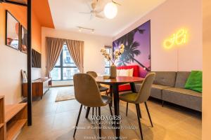 a living room with a table and chairs and a couch at Mossaz at Empire Damansara by Wodages in Kuala Selangor