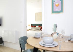 a dining room table with plates and glasses on it at Luxury Apt w Wifi & Pvt parking in Chertsey +27 photos