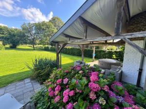 a garden with pink flowers in front of a building at Le gîte d'Hayen in Sprimont +19 photos