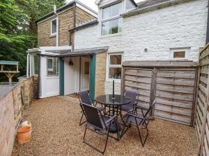 eine Terrasse mit Tisch und Stühlen vor einem Gebäude in der Unterkunft Woodcutters Cottage in Haltwhistle