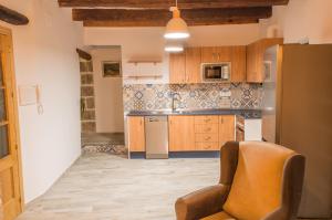 a kitchen with wooden cabinets and a chair at Casa de Mamachon in Cazorla