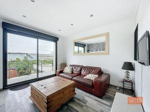 a living room with a couch and a large window at Le Petit Loft in Wimille +2 photos