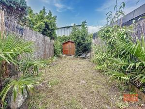 a garden with a wooden door in a fence at Le Petit Loft in Wimille