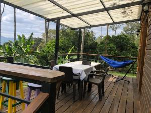 a patio with a table and chairs on a deck at Cabaña tipo glamping en finca cafetera con zonas verdes, avistamiento de aves, paisaje cafetero in San Francisco