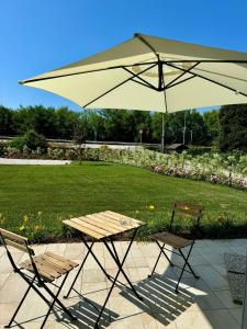 a picnic table and two chairs under an umbrella at LA ROSA DEL SILE in Quarto dʼAltino +37 photos