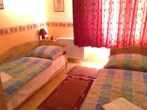 a bedroom with two beds and a window at Babati Apartmanház in Zalakaros