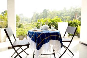 een blauwe en witte tafel en stoelen op een balkon bij Hidden heaven holidays and camping organisers in Haputale