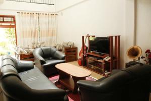 een woonkamer met twee leren stoelen en een televisie bij Hidden heaven holidays and camping organisers in Haputale