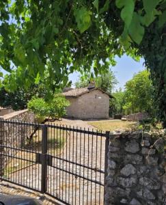 an old gate with a stone wall and a building at La casa nella roccia Colline umbre in Battiferro