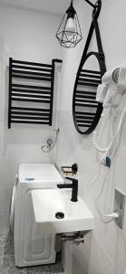 a bathroom with a white sink and a hair dryer at Lipowy Kąt in Gołdap