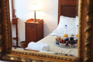 eine Spiegelung eines Bettes mit einem Teller Essen in der Unterkunft Pano Meria Venetian Style Studio I in Oia