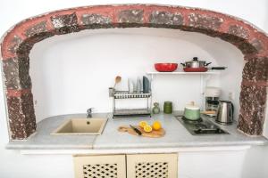 eine Küche mit einem Torbogen über einer Theke mit Spüle in der Unterkunft Pano Meria Venetian Style Studio I in Oia + 12 Fotos
