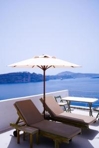 zwei Liegestühle und ein Sonnenschirm auf einem Boot in der Unterkunft Pano Meria Venetian Style Studio I in Oia