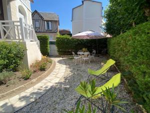 a patio with a table and chairs and an umbrella at Villa Soleil Levant in Deauville