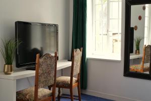 a tv sitting on a table with two chairs at Les chambres de l'Elysée in Pontrieux