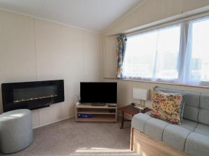 a living room with a couch and a flat screen tv at Tri-Star House in Charmouth