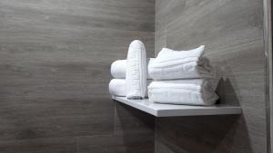 a pile of towels sitting on a shelf in a bathroom at Hotel Salvador in Bailén