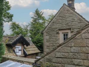 une ancienne maison en pierre avec une fenêtre et un toit dans l'établissement Whim Cottage, à Hathersage