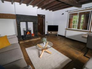 un salon avec un canapé et une cheminée dans l'établissement Whim Cottage, à Hathersage