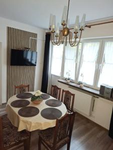 a dining room with a table with chairs and a chandelier at Dom - Nielisz - do wynajęcia in Nielisz