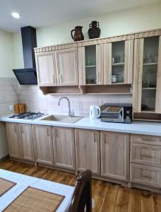 a kitchen with wooden cabinets and a sink at Dom - Nielisz - do wynajęcia in Nielisz +8 photos