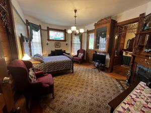 a bedroom with a bed and a couch and a tv at Innisfree Bed & Breakfast in South Bend