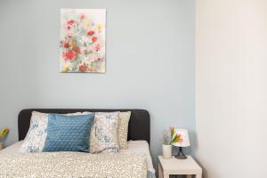 a bedroom with a bed and a painting on the wall at SuperApart Zdobnicza 4 in Warsaw