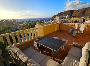 a patio with a table and chairs on a balcony at Sea view duplex private jacuzzi, garden, terras and shared pool in Palm-Mar