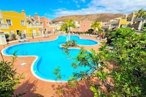 an image of a swimming pool at a resort at Sea view duplex private jacuzzi, garden, terras and shared pool in Palm-Mar