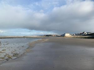 an empty beach with buildings in the background at Le Petit Loft in Wimille