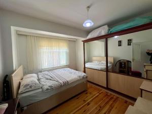 een slaapkamer met een bed en een grote spiegel bij Marin DenizeR Tatilevi in Amasra +2 foto's