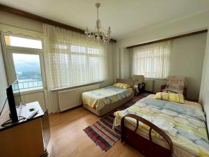 een slaapkamer met twee bedden en een televisie bij Marin DenizeR Tatilevi in Amasra