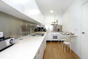 een keuken met witte kasten en witte aanrechtbladen bij Apartamento La Flamenquita in Málaga