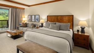 a bedroom with a large bed and a living room at 309 VILLAGE GREEN By Stowe Mountain Rentals in Stowe