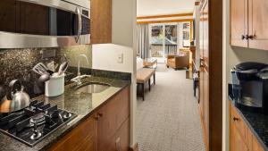 a kitchen with a sink and a living room at 309 VILLAGE GREEN By Stowe Mountain Rentals in Stowe