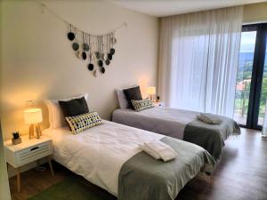 a bedroom with two beds and a window at Villa Amores Riverview - Your Scenic Getaway - uChill in Vila Nova de Cerveira +38 photos
