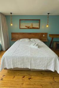 a bedroom with a large bed with a white comforter at Graffi Beach House in Florianópolis