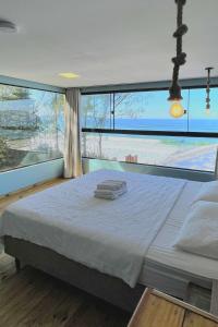a large bed in a room with a large window at Graffi Beach House in Florianópolis +129 photos
