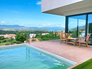 a house with a swimming pool and a table and chairs at Villa Amores Riverview - Your Scenic Getaway - uChill in Vila Nova de Cerveira
