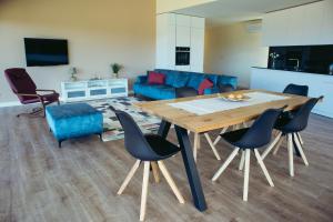 a living room with a wooden table and chairs at Villa Amores Riverview - Your Scenic Getaway - uChill in Vila Nova de Cerveira