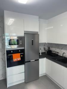 a kitchen with a refrigerator and a microwave at Logroño Centro Impecable Aire Acondicionado Parking in Logroño