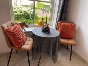 a table and two chairs in a room with a window at Room D no bathroom, geen badkamer in Aalten