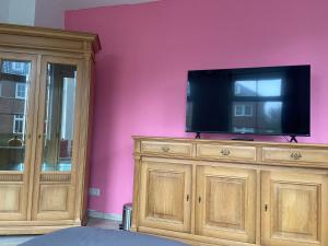 a tv on top of a wooden dresser in a room at Room D no bathroom, geen badkamer in Aalten