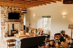 un salon avec un canapé et une cheminée dans l'établissement No1 Burgie Mains Cottage, à Forres