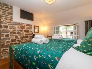 a bedroom with a bed with towels on it at Fishermen's Cottage in Chulmleigh
