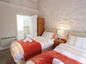 a bedroom with two beds and a window at Ty Llaeth Cottage in Tywyn