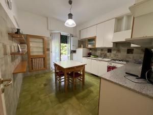 a kitchen with white cabinets and a table and chairs at Don Comò in Sulmona