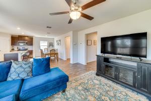 a living room with a blue couch and a flat screen tv at San Antonio Home with Pool Access 11 Mi to SeaWorld in San Antonio