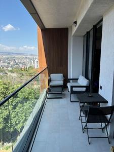 a balcony with chairs and a view of a city at Krtsanisi Grande apartment in Tbilisi City