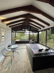 una grande stanza con una vasca e un tavolo di Cabañas Tahamí con jacuzzi cerca al Aeropuerto a Guarne